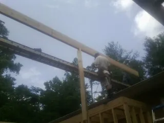 Carpenter setting a ridge beam over a new addition frame — Ice Dam Removal by Roofing Brothers in Westhampton Beach