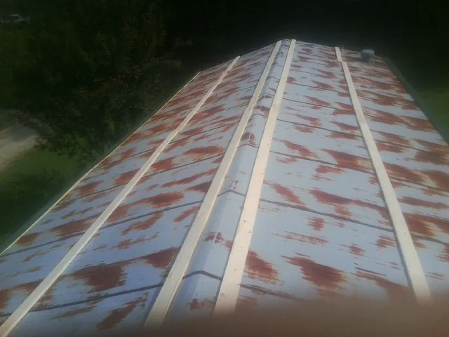 Rusted metal roof panels with new wood purlins before replacement — Storm Damage Roof Repair in Westhampton Beach by Roofing Brothers