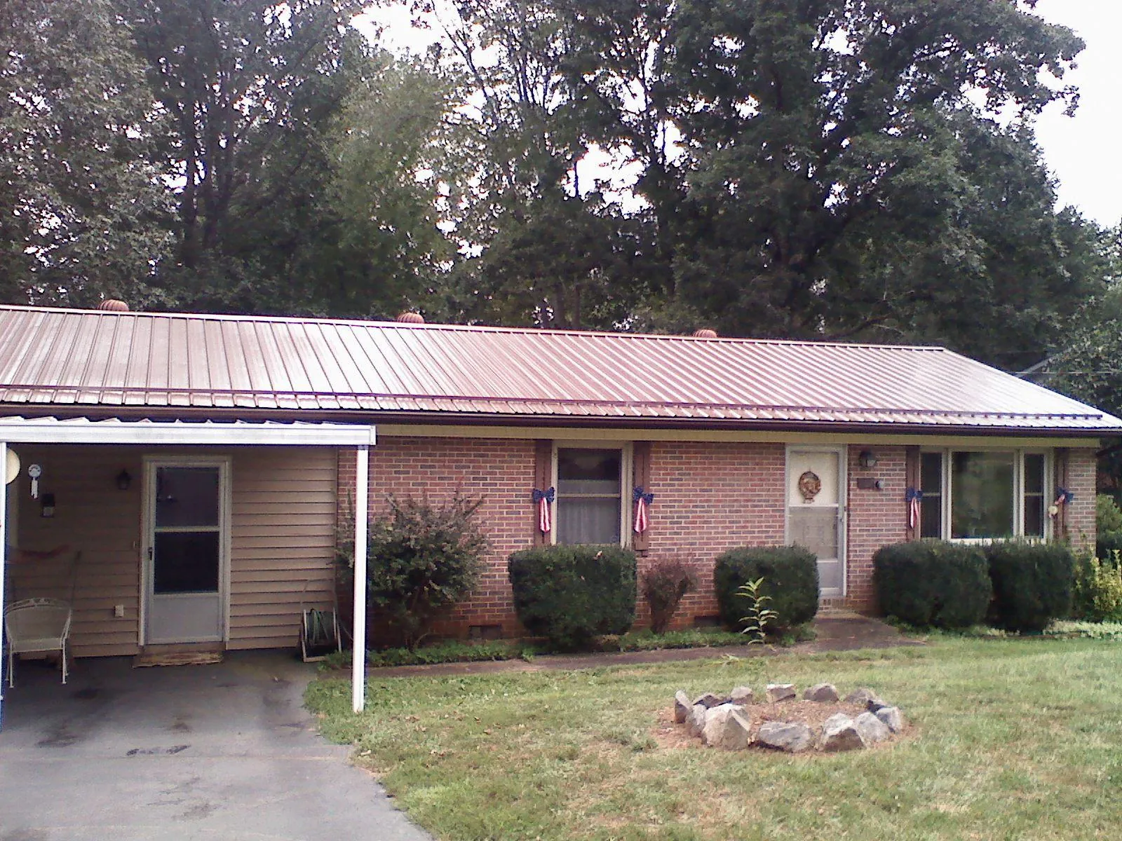 Bronze metal roof and carport on a brick ranch home — Roof Repair work by our crew in Westhampton Beach